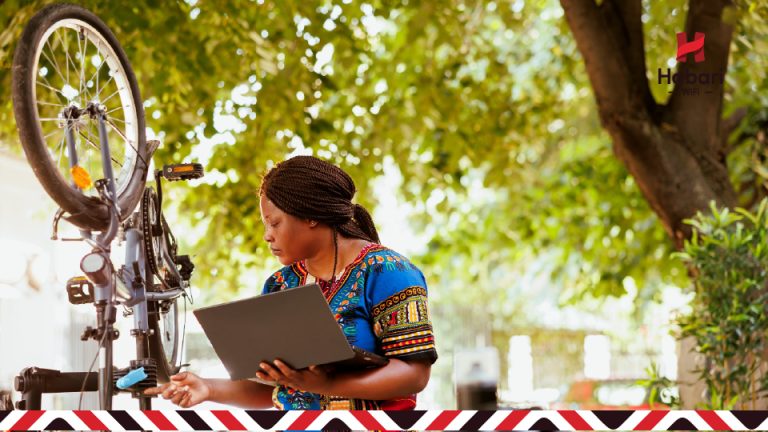 Local female entrepreneur repairing a bicycle in Tanzania, representing small business innovation and growth.